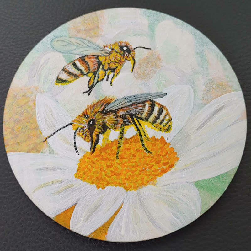 Runde Holzscheibe, bemalt mit zwei Bienen auf einer weißen Margerite