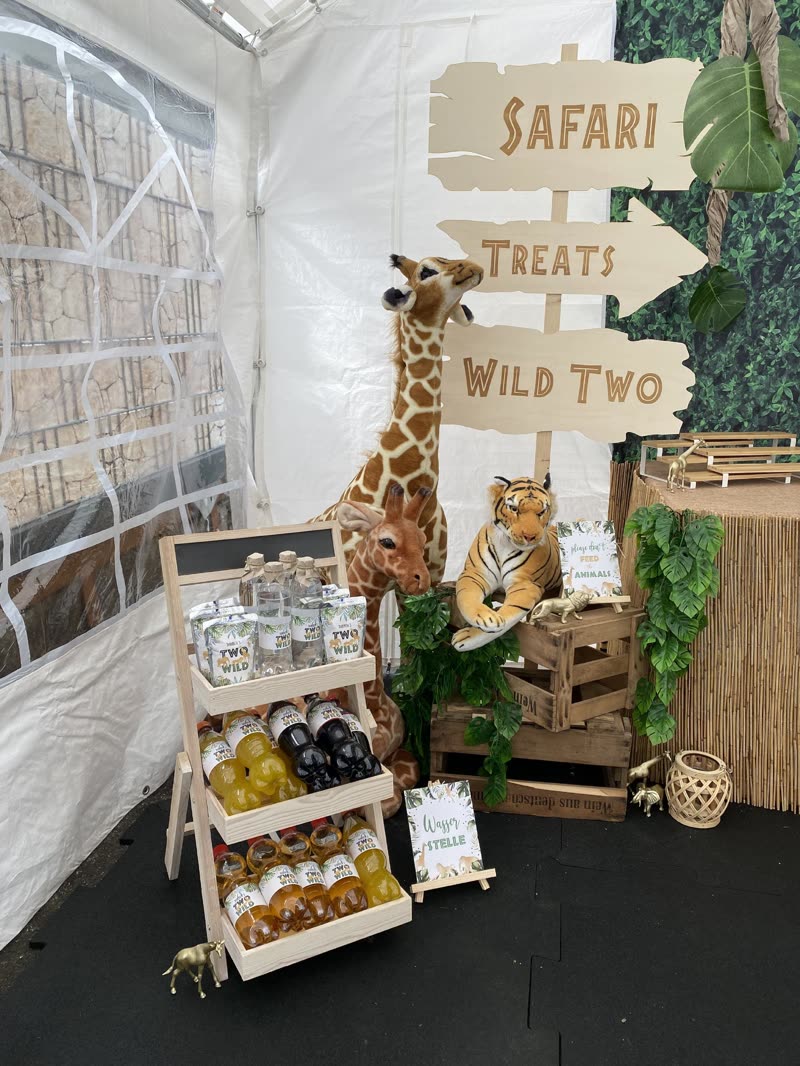 Hölzerner Wegweiser mit den Schildern „Safari“, „Treats“ und „Wild Two“